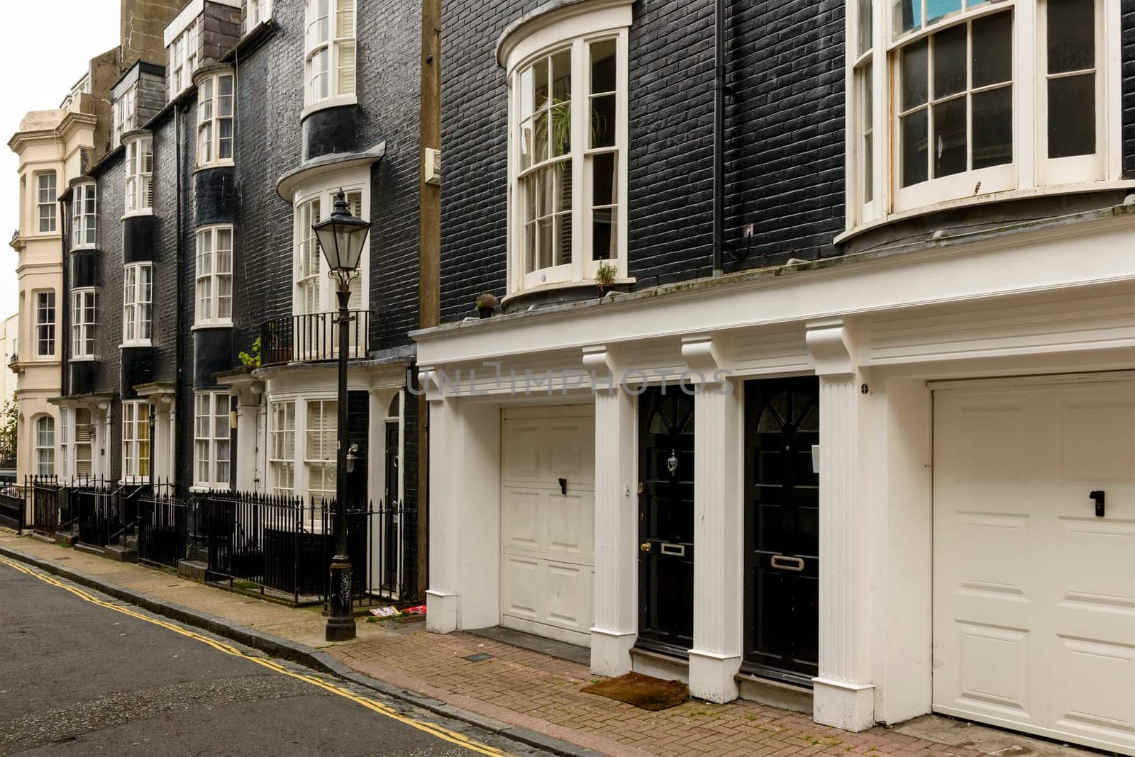 foreshortening of old black and white houses on a street in touristic sea town,  Brighton, East Sussex.