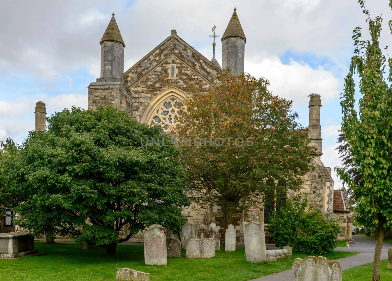 view of ancient  stone church and its cemetery in small  historic village of Rye, East Sussex ..