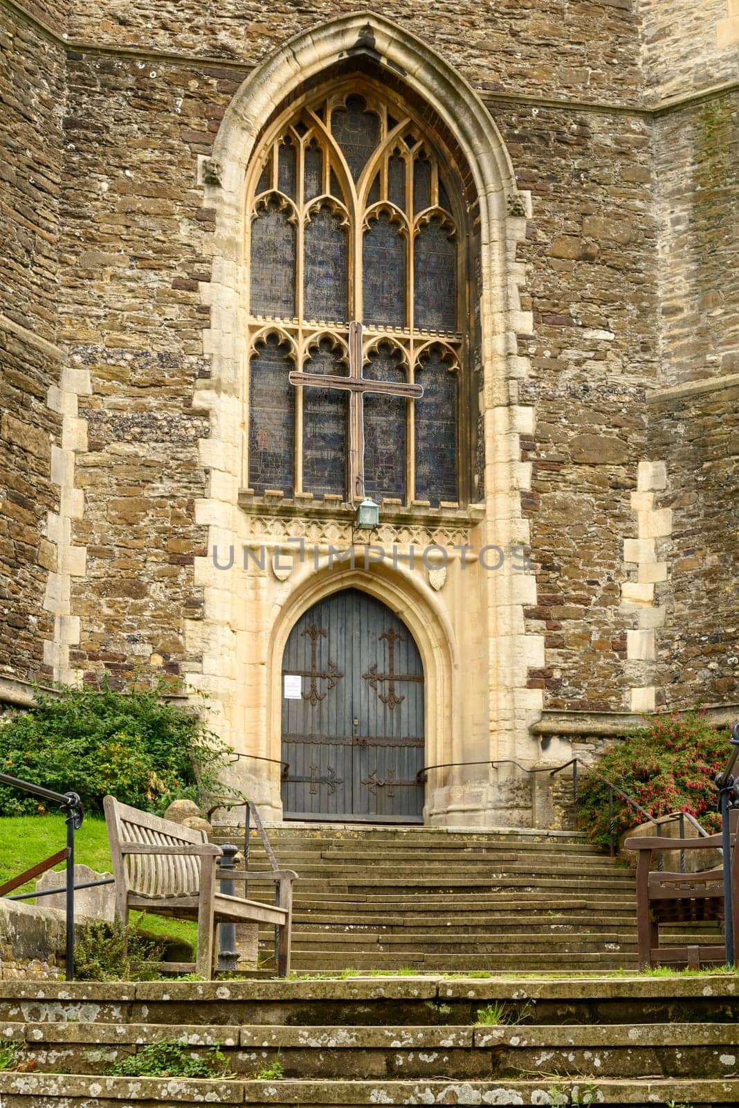 foreshortening with a bench on the stairs of the entrance of stone church  in the historic village of Hastings, East Sussex .