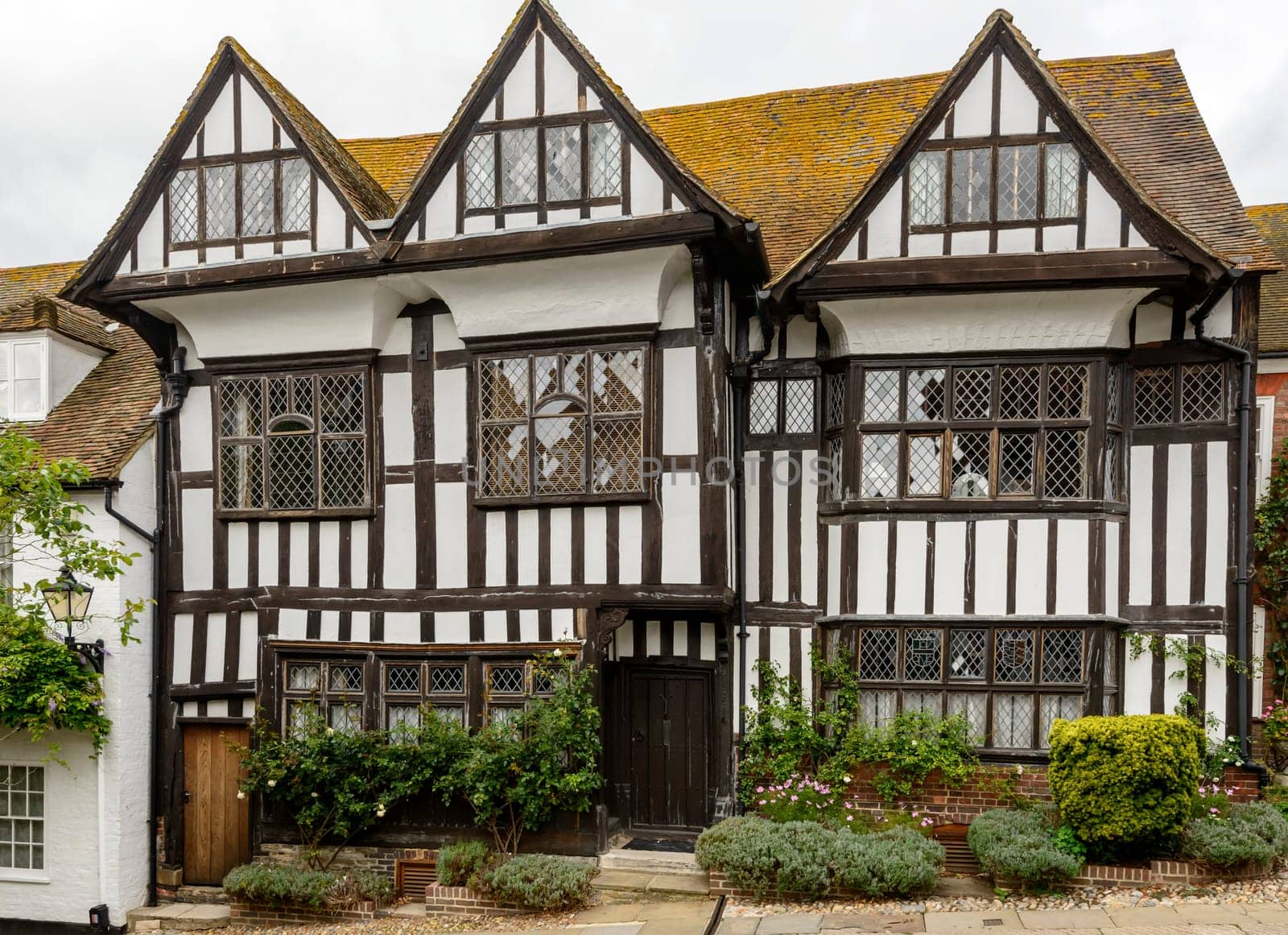 view of old  wattle houses with flowers on a uphill street in the historic village of Rye, East Sussex .