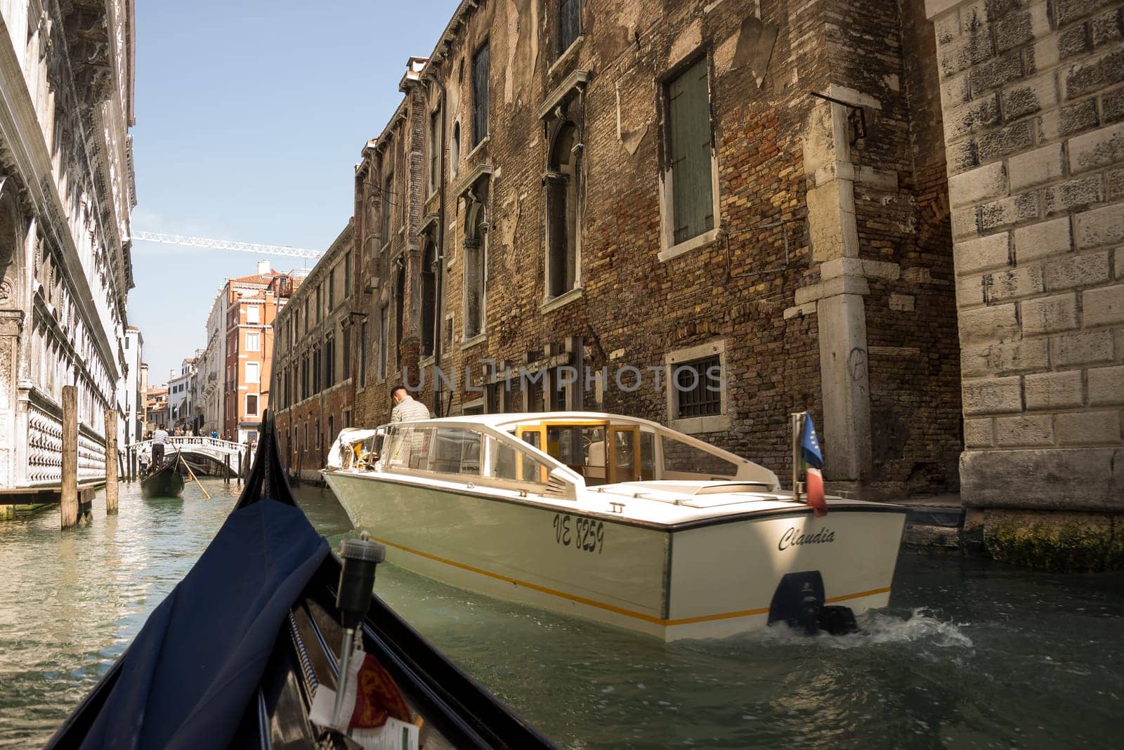 Venice, Italy- March 30, 2014:Captain leads the boat and the gondolier is transporting tourists on the street
