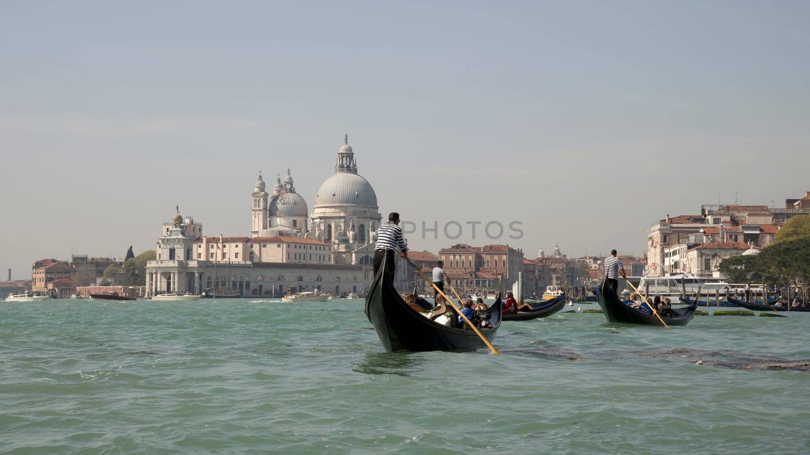 Venice, Italy, March 30, 2014: The gondoliers floats on a gondolas with tourists