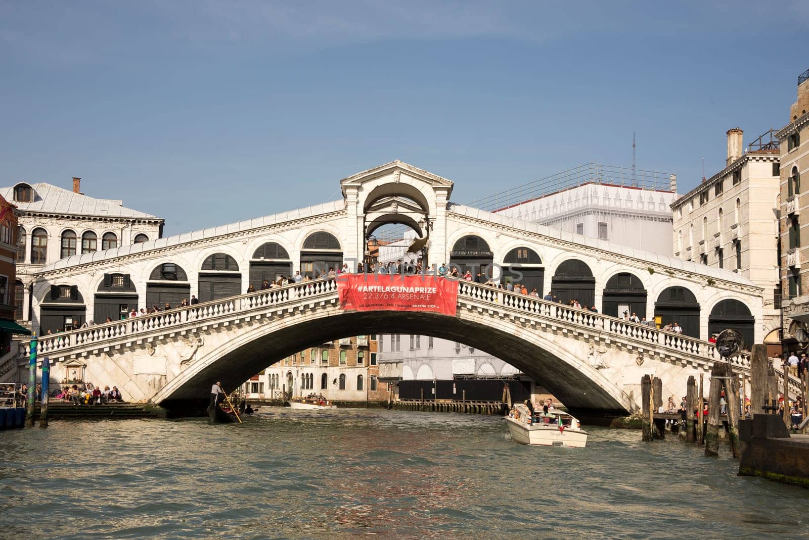 VENICE,ITALY-MARCH 30-Ships sailing under the bridge Rialto with walking tourists  in March 30,2014 in Venice