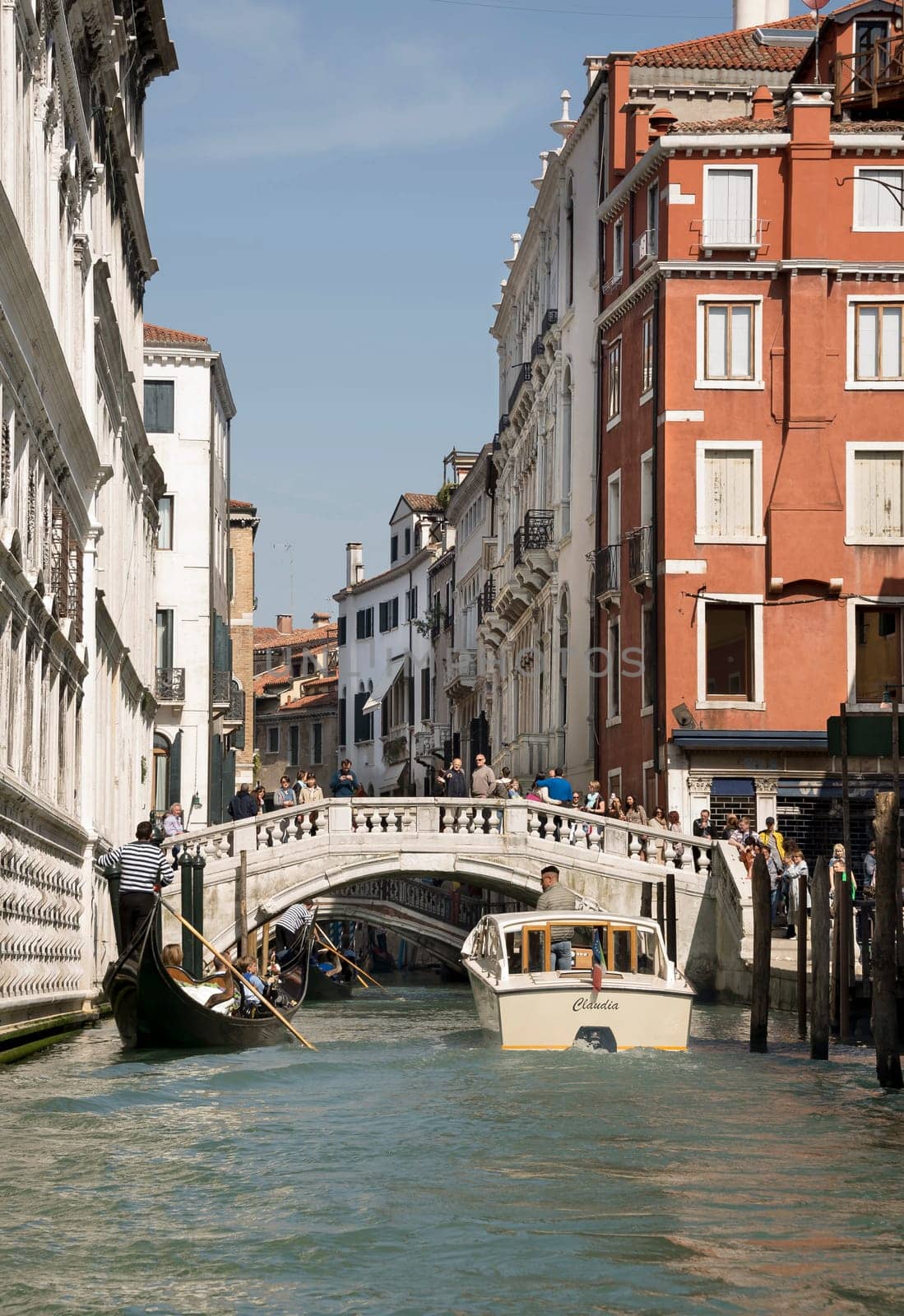Venice, Italy- March 30, 2014:Ships sailing under the bridge with walking tourists