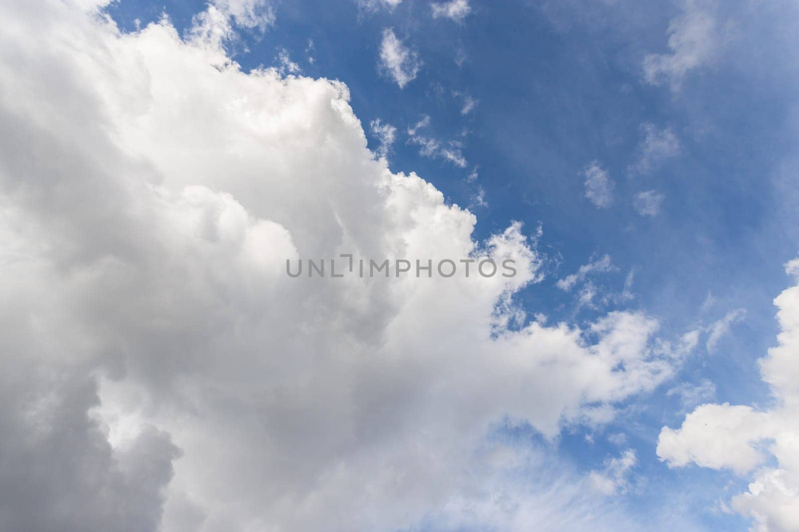 Blue sky background with cumulus of white and gray clouds. Bad weather is coming.