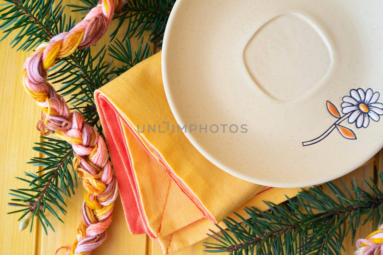 Empty rustic light plate over pastel table. Flat lay, with spruce branch