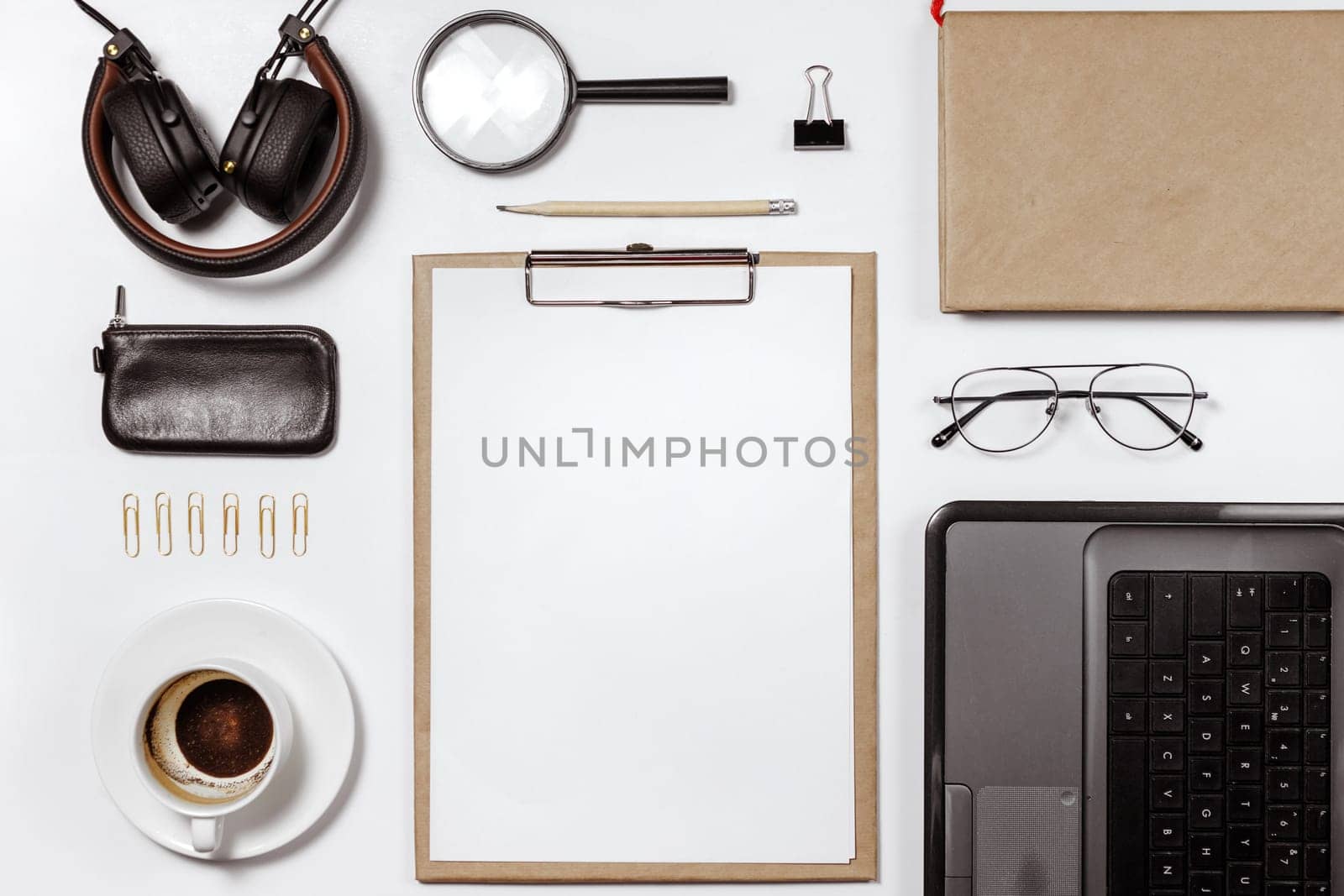 Flat lay of stylish male workplace with clip folder, laptop and business accessories on white background. Copy space