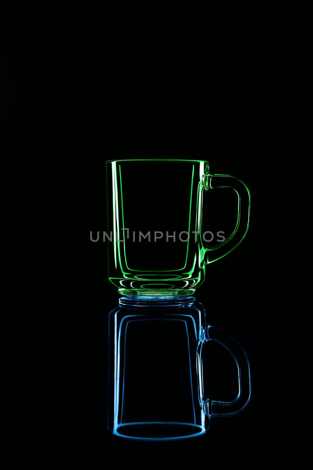 Just a glass on a black background with a reflection. Green and blue colors. Isolated.