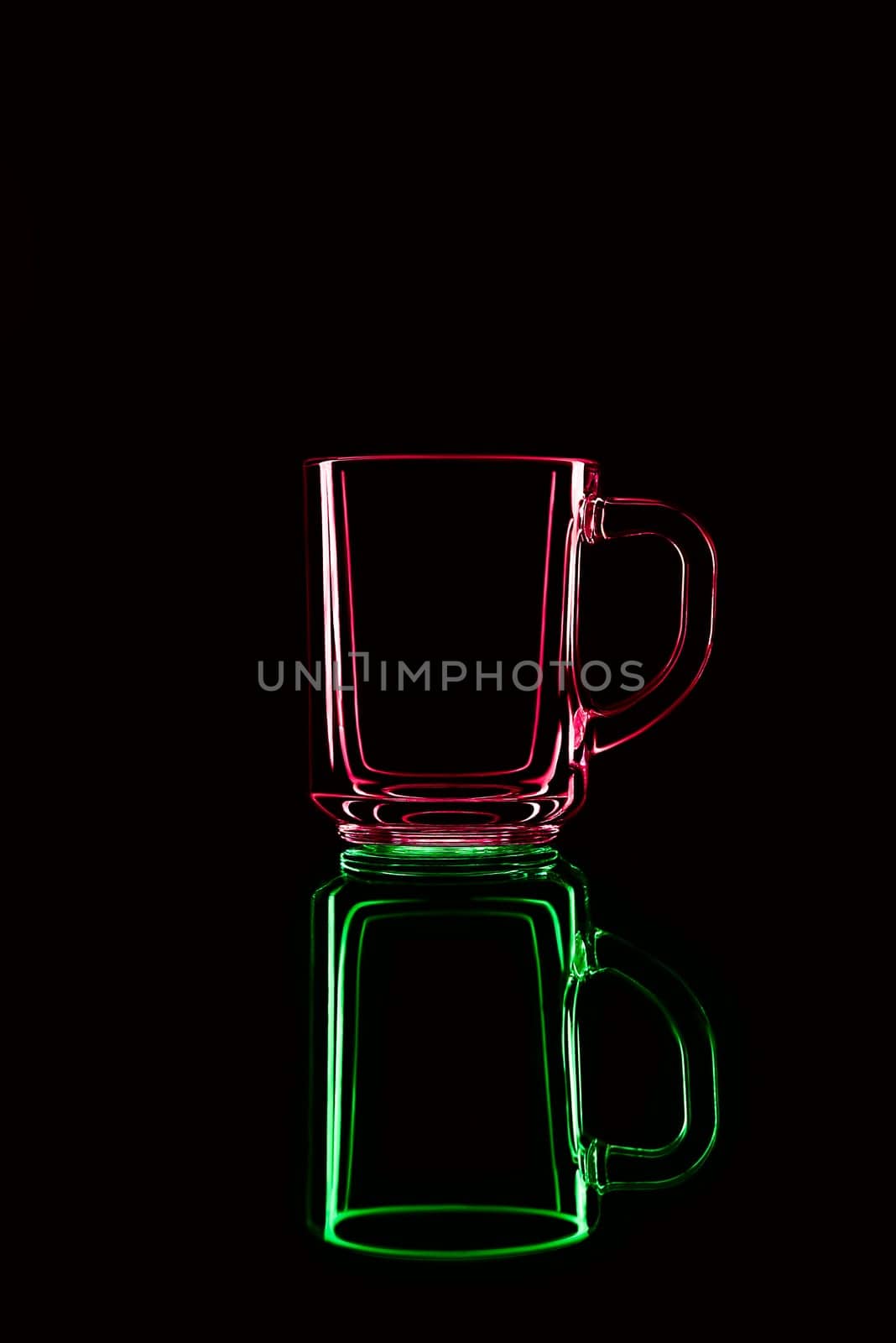 Just a glass on a black background with a reflection. Red and green. Isolated.