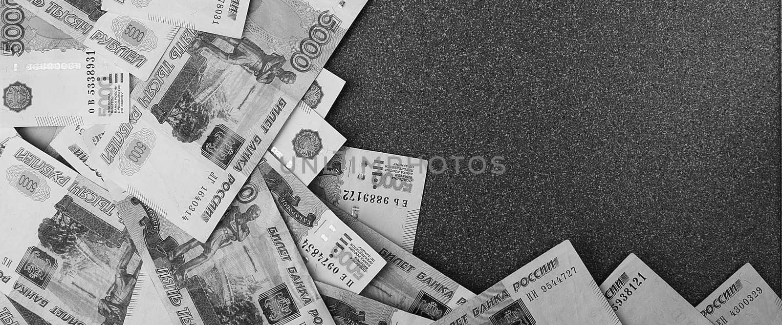 Russian cash banknotes of five thousand rubles, scattered on a gray background, there is a place for the inscription and text. Layout, layout.
