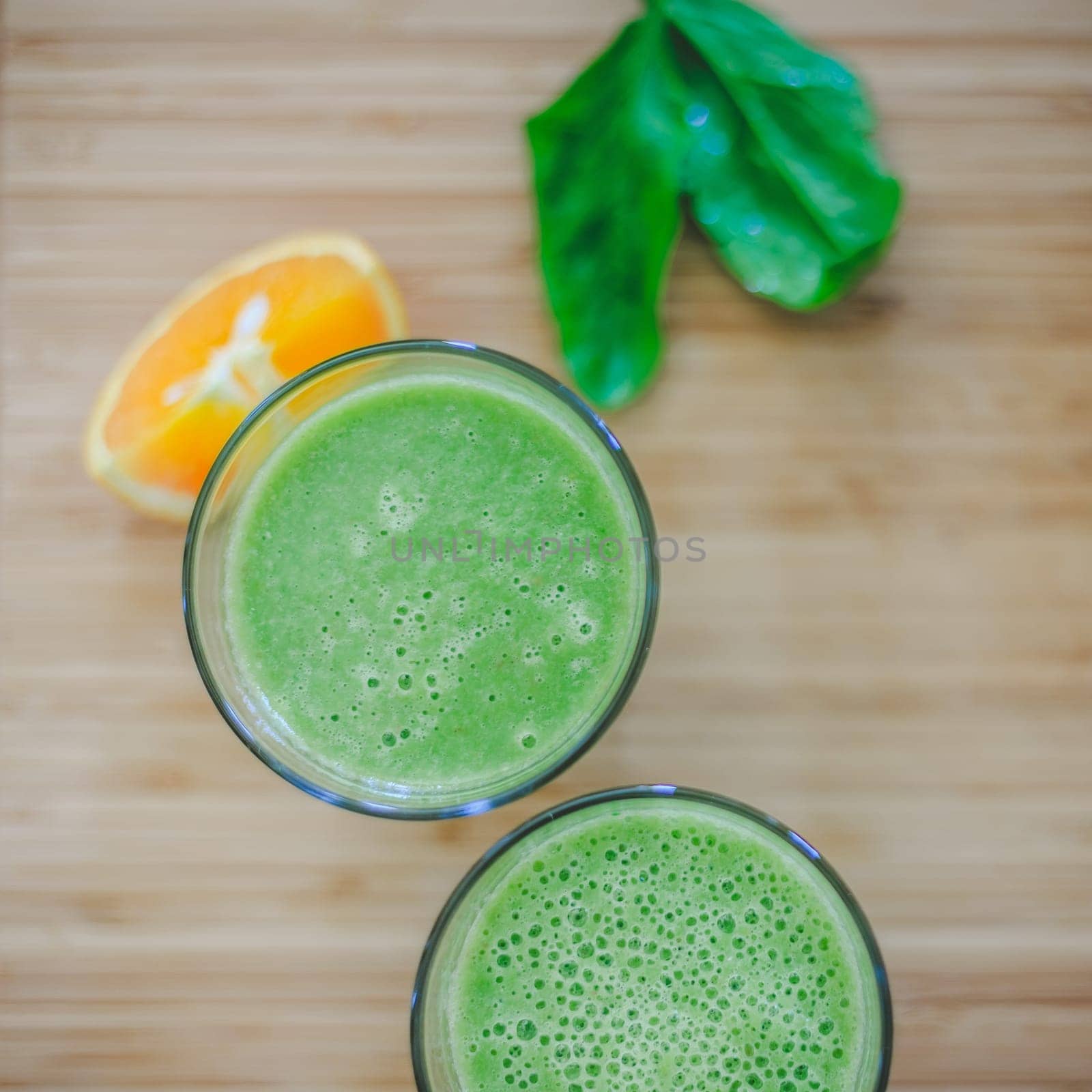 Arrangement of a fresh green healthy smoothies and fruits on a wooden background.
