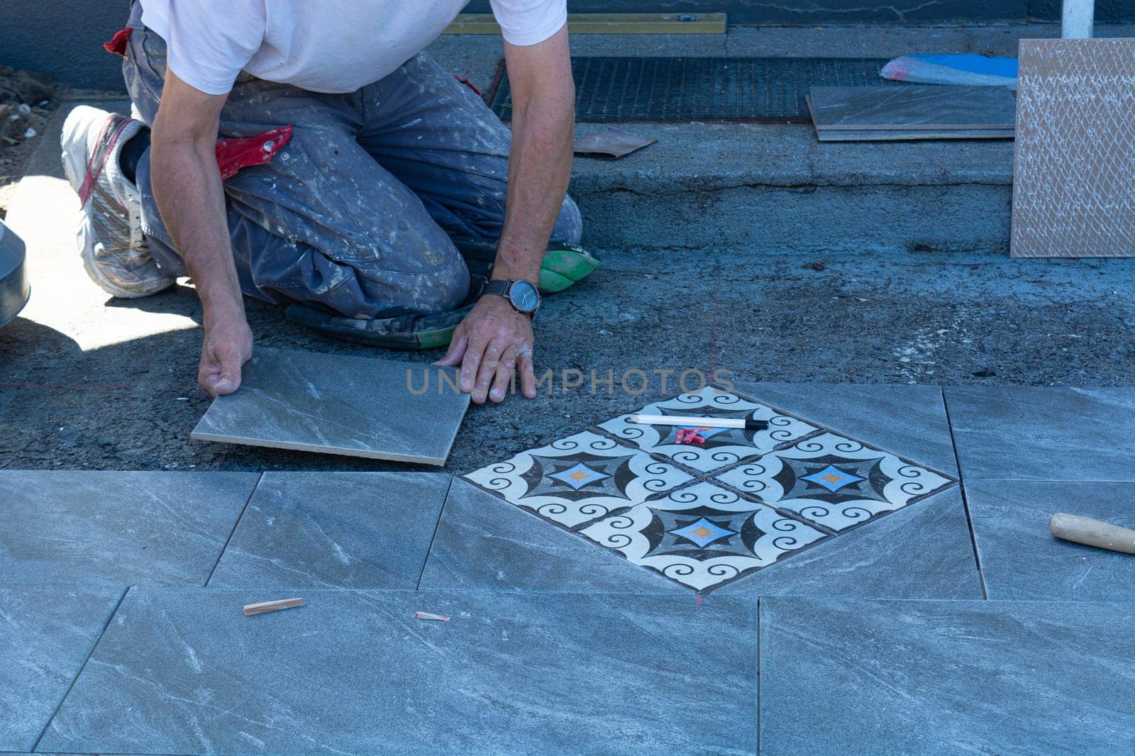 Laying ceramic floor tiles - man hands closeup