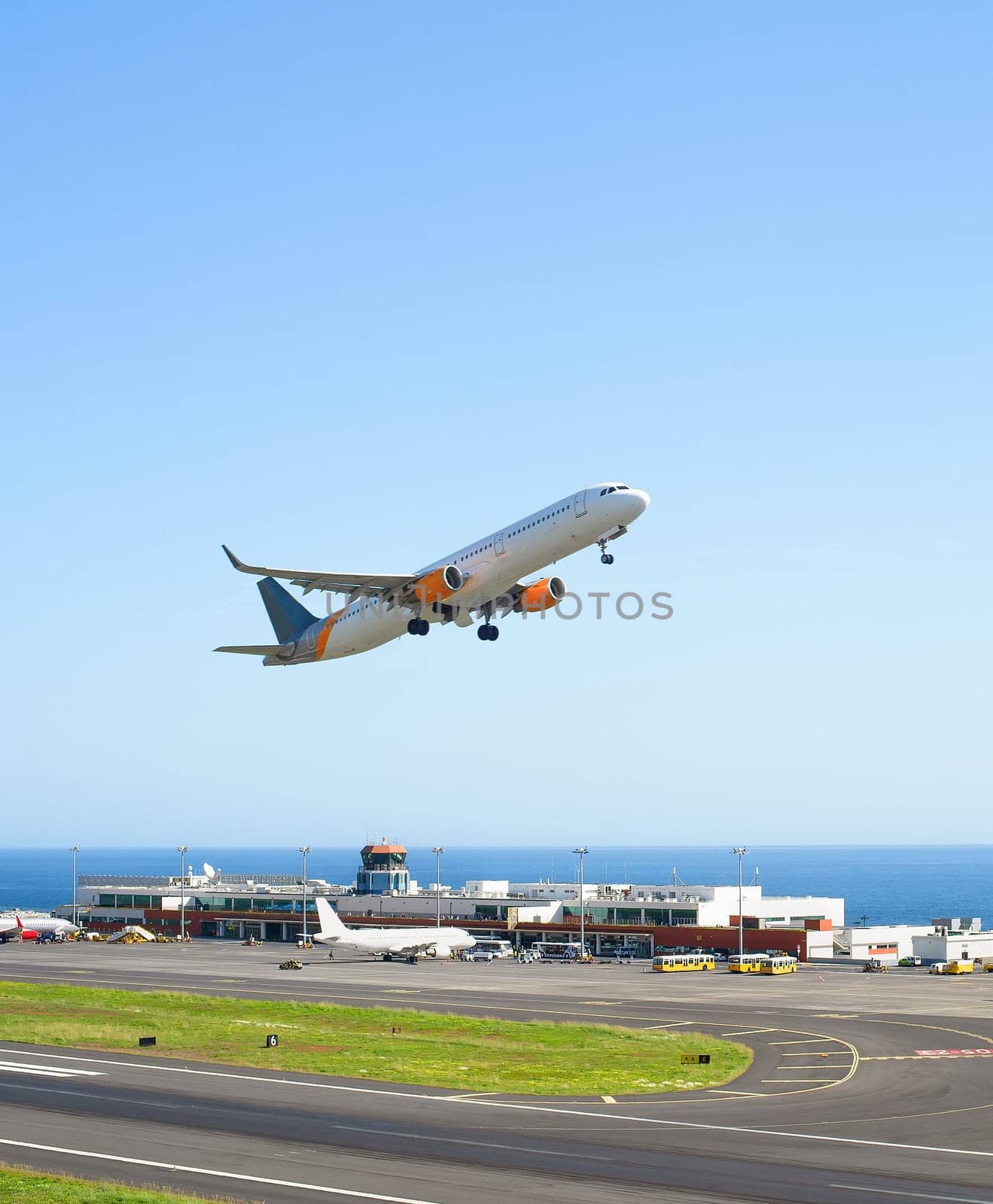 Airplane taking off International Airport skyward view, planes parked by terminal, sunshine, seascape, Funchal, Madeira