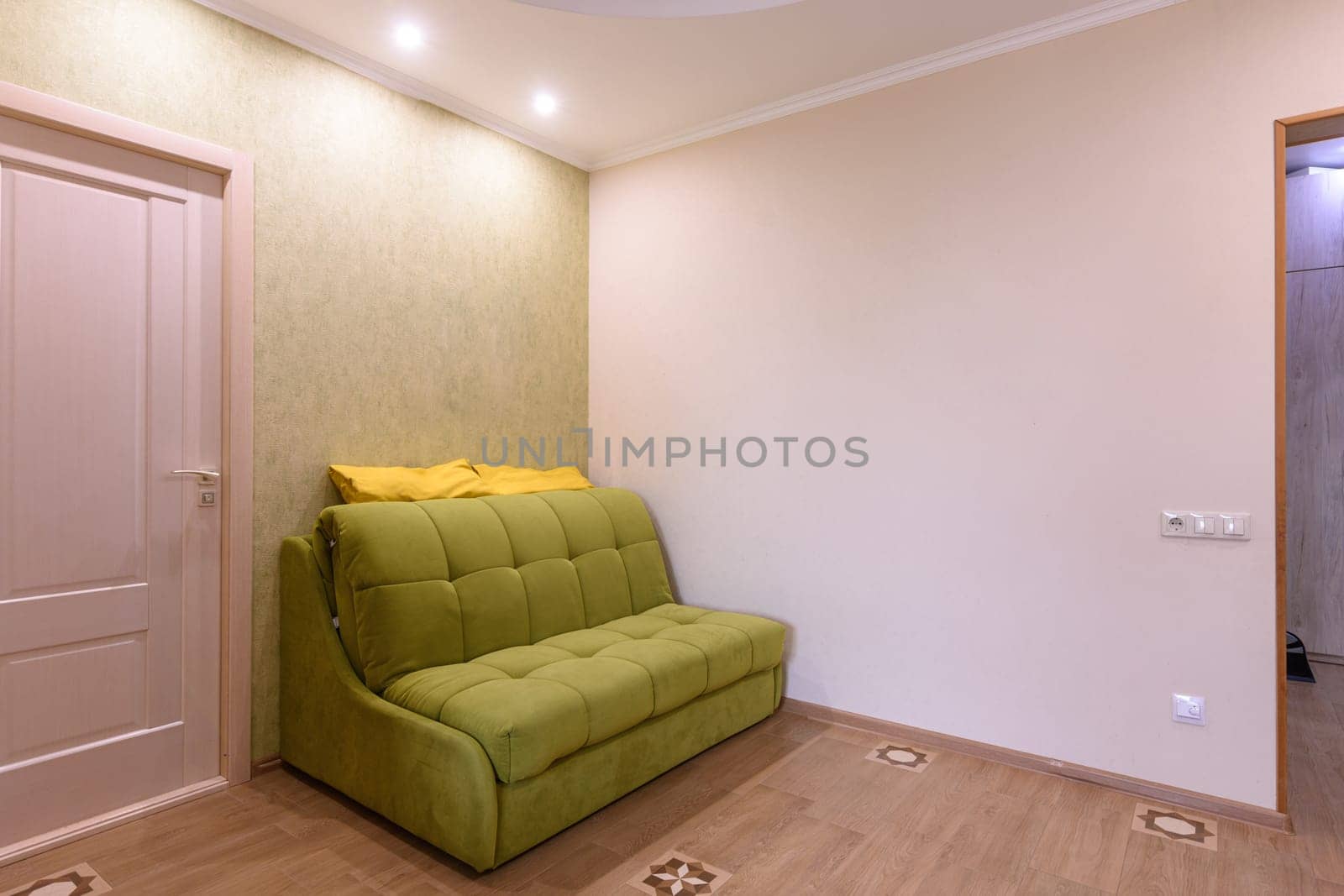 Fragment of the living room interior in a small apartment, the sofa stands against the wall