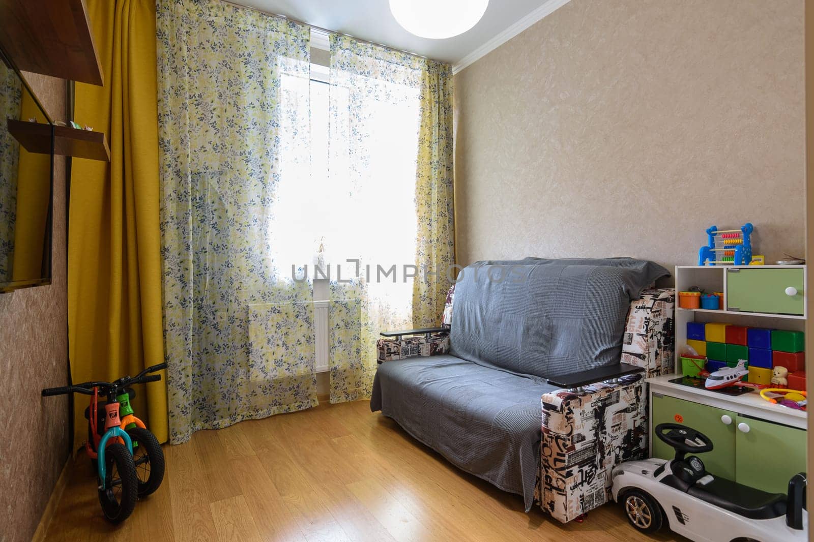 Anapa, Russia - March 1, 2021: Interior of a small children's playroom with a sofa and toys