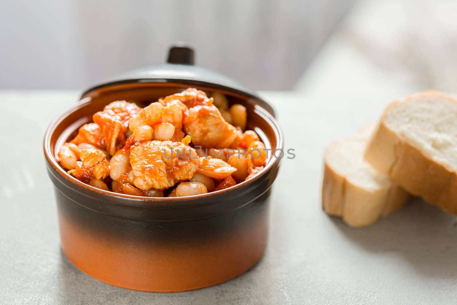 Steamed white beans with meat in tomato sauce. Homemade food concept. Close up. Selective focus.