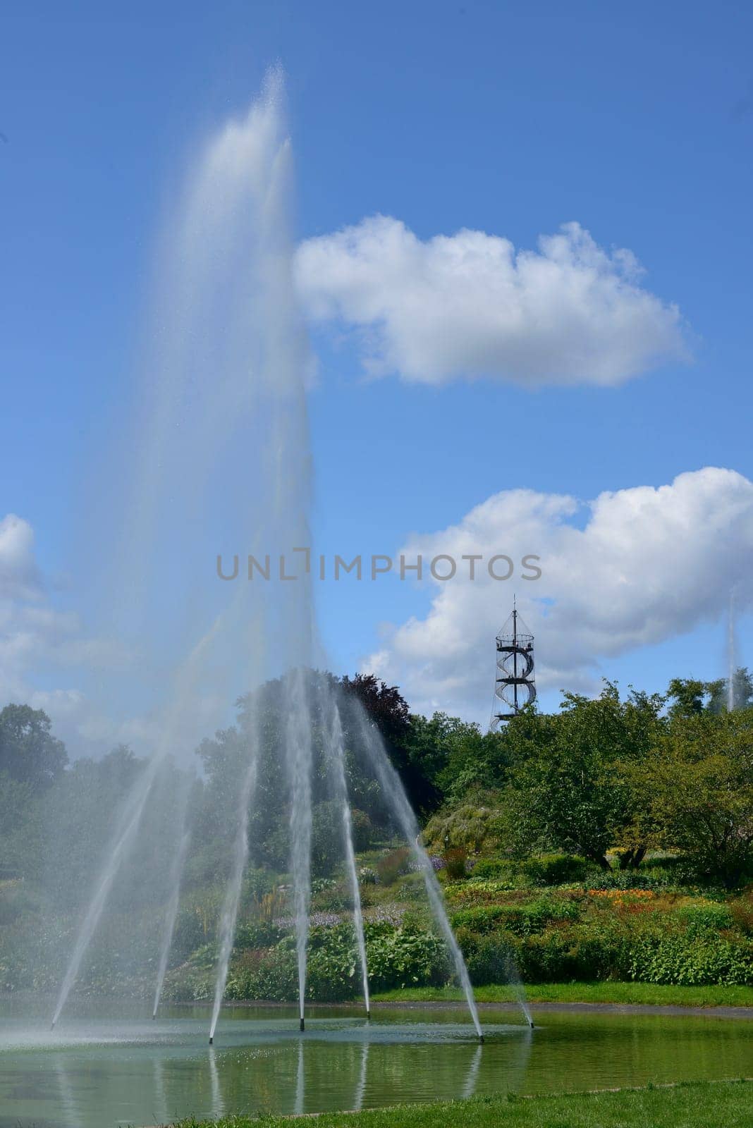 Stuttgart, Germany, 2012 july 22th, high water jet in fountain in the park, in background the steel structure of the panoramic tower..