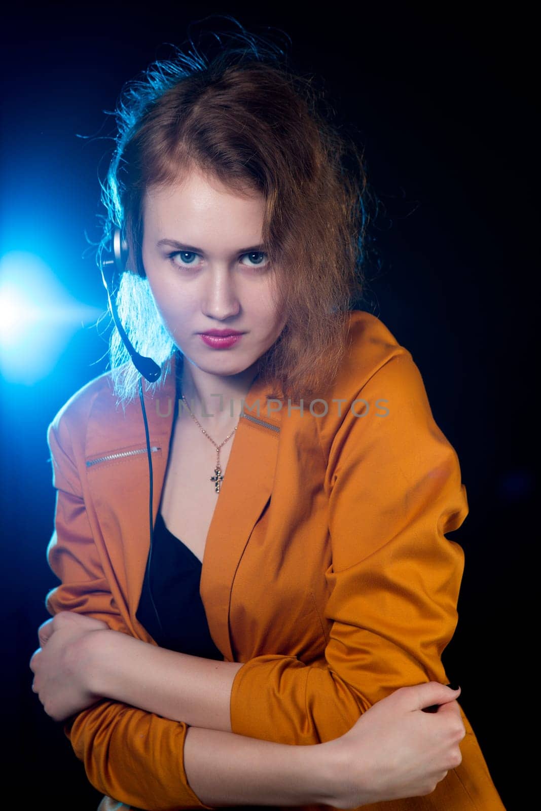 Young beautiful woman-operator with headphone smiles, it is isolated on black background.
