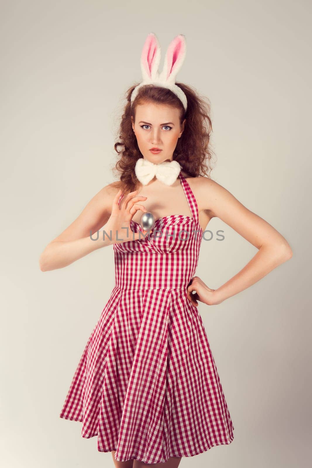 sexy girl wearing easter bunny costume with egg