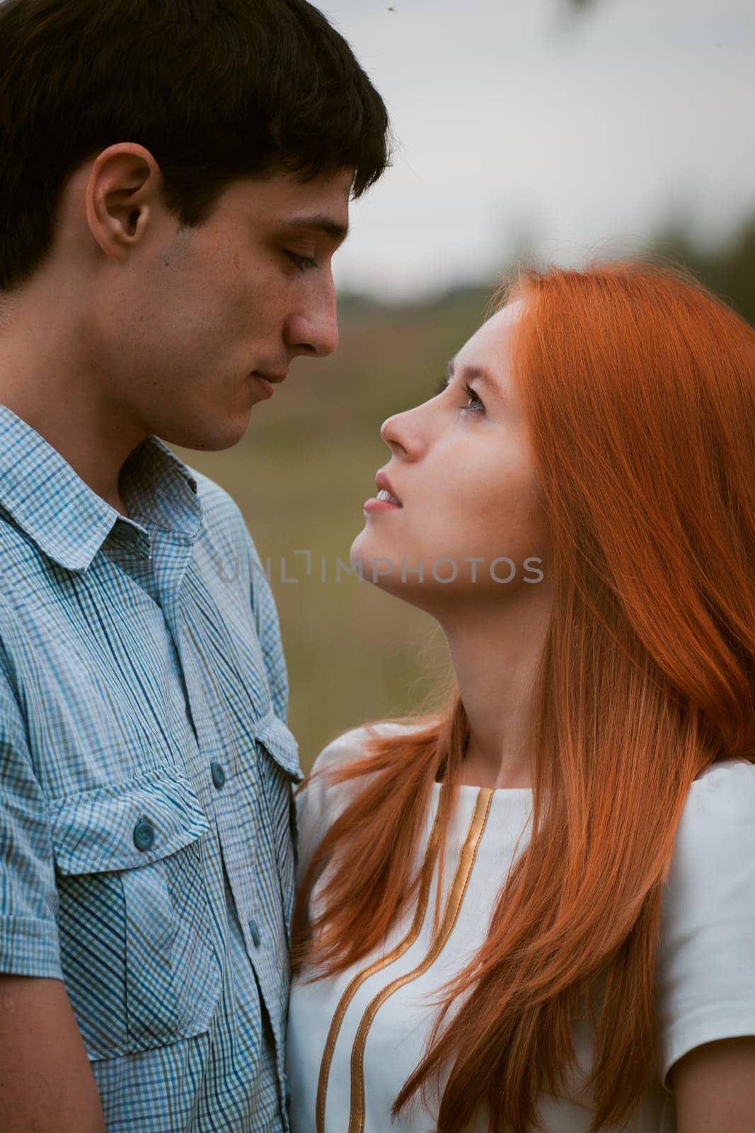 Happy young couple kissing on a ripe field