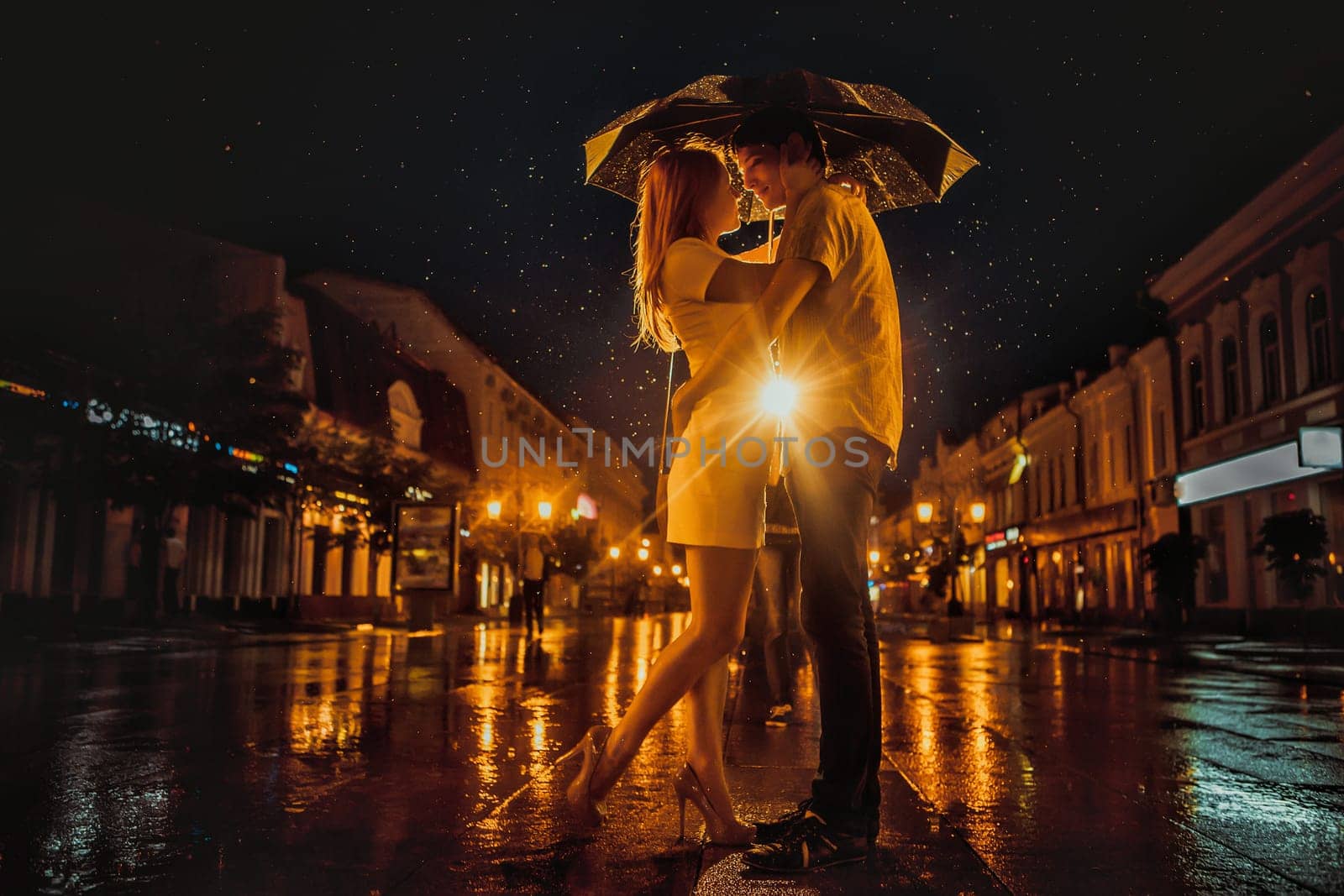 Love in the rain / Silhouette of kissing couple under umbrella