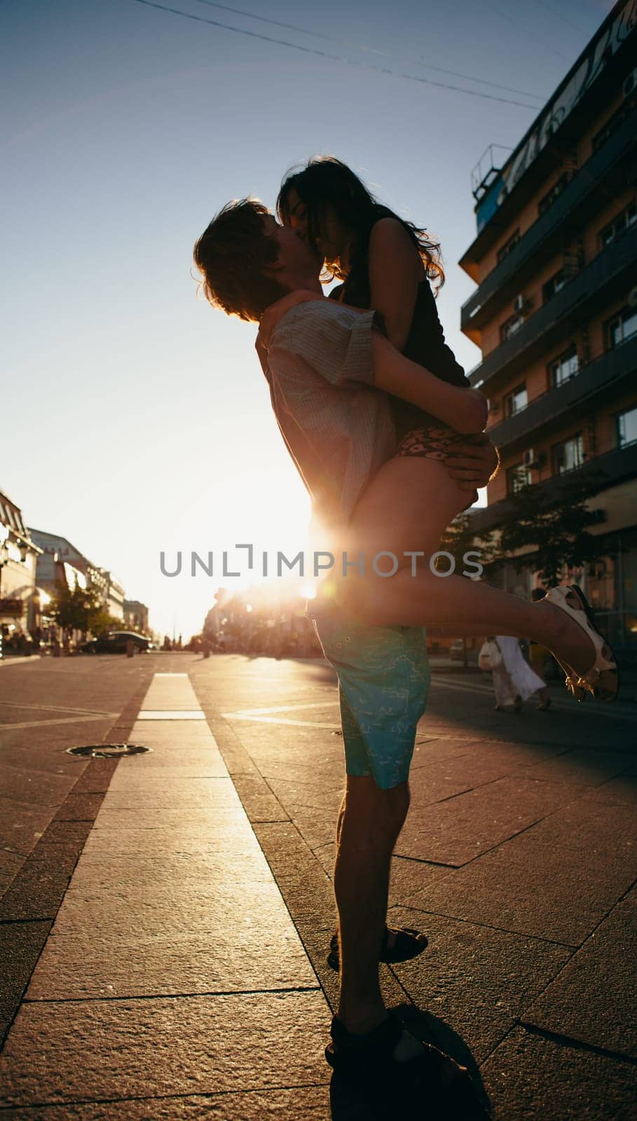 Young couple kissing over sunset