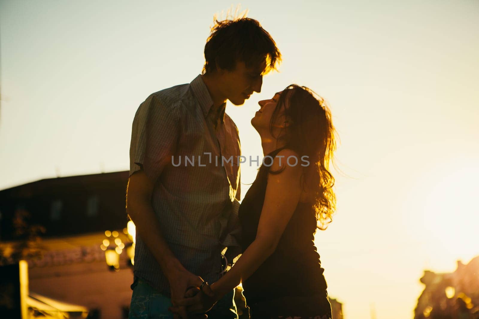 Young couple kissing over sunset
