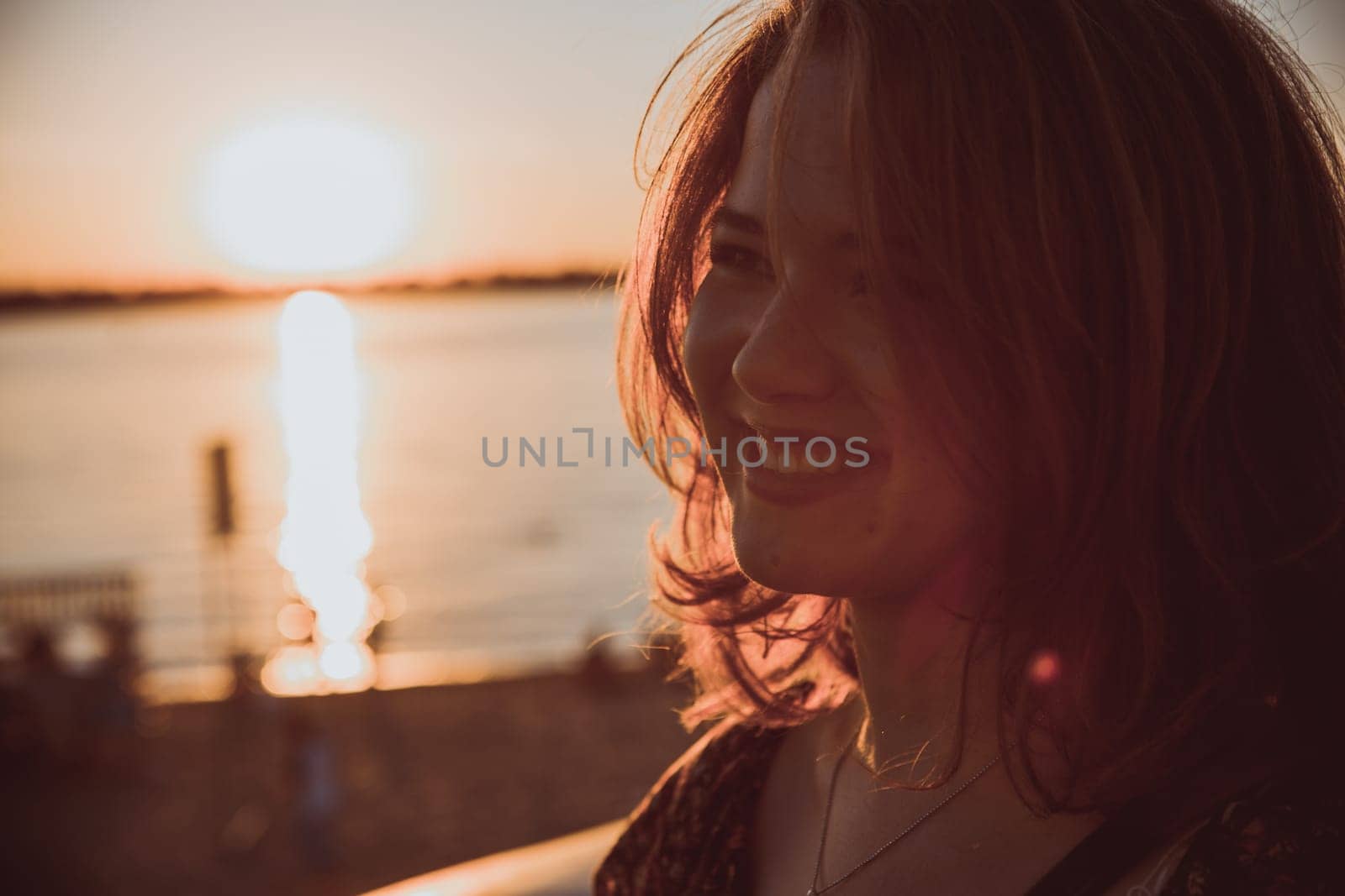 Beautiful young brunette girl sitting outdoors near the river