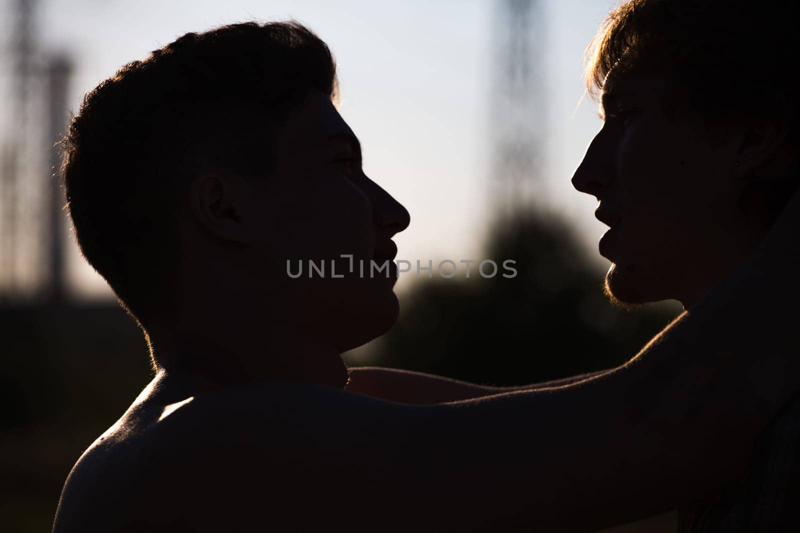 Silhouette of two men about to kiss