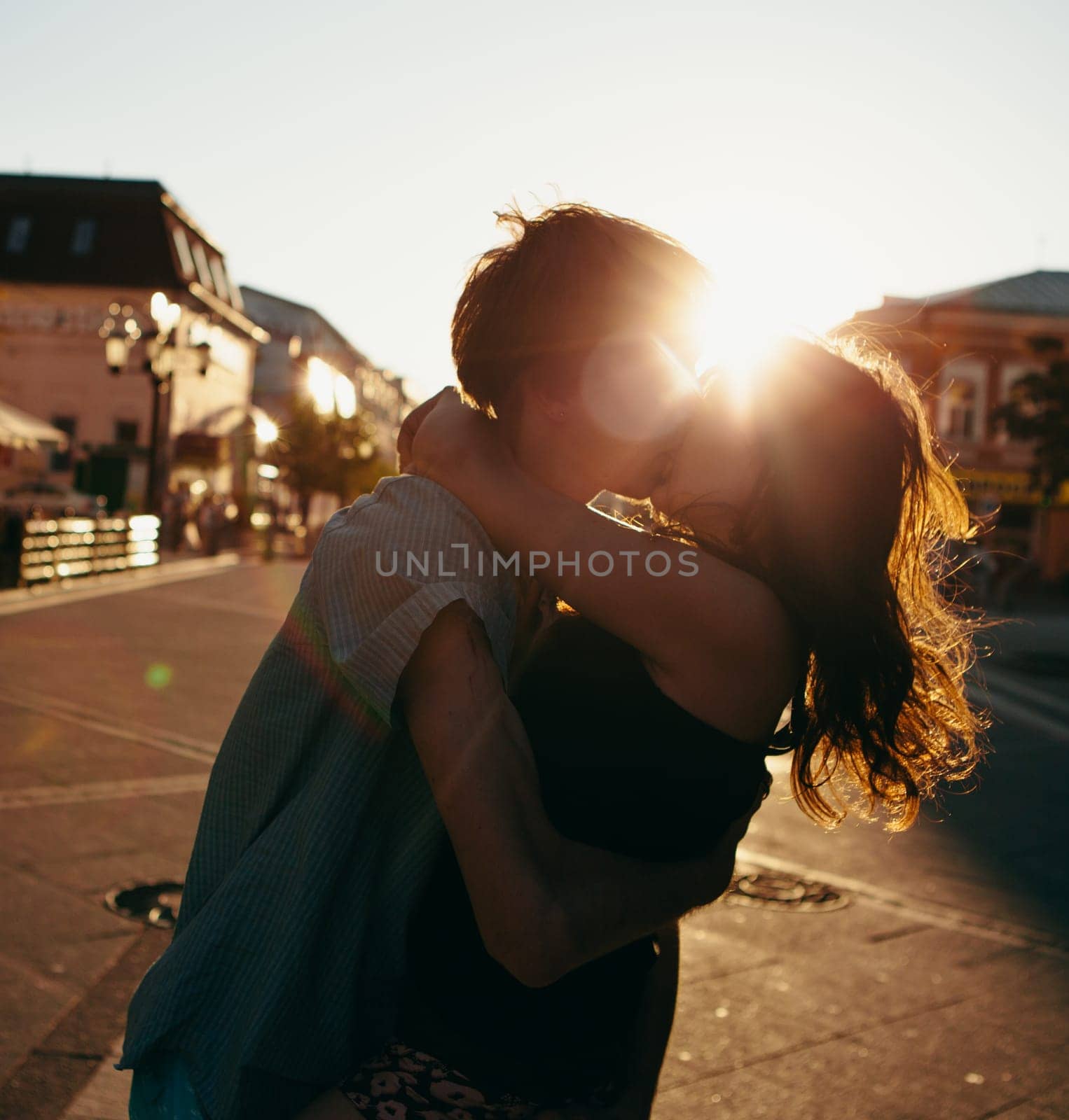 Young couple kissing over sunset