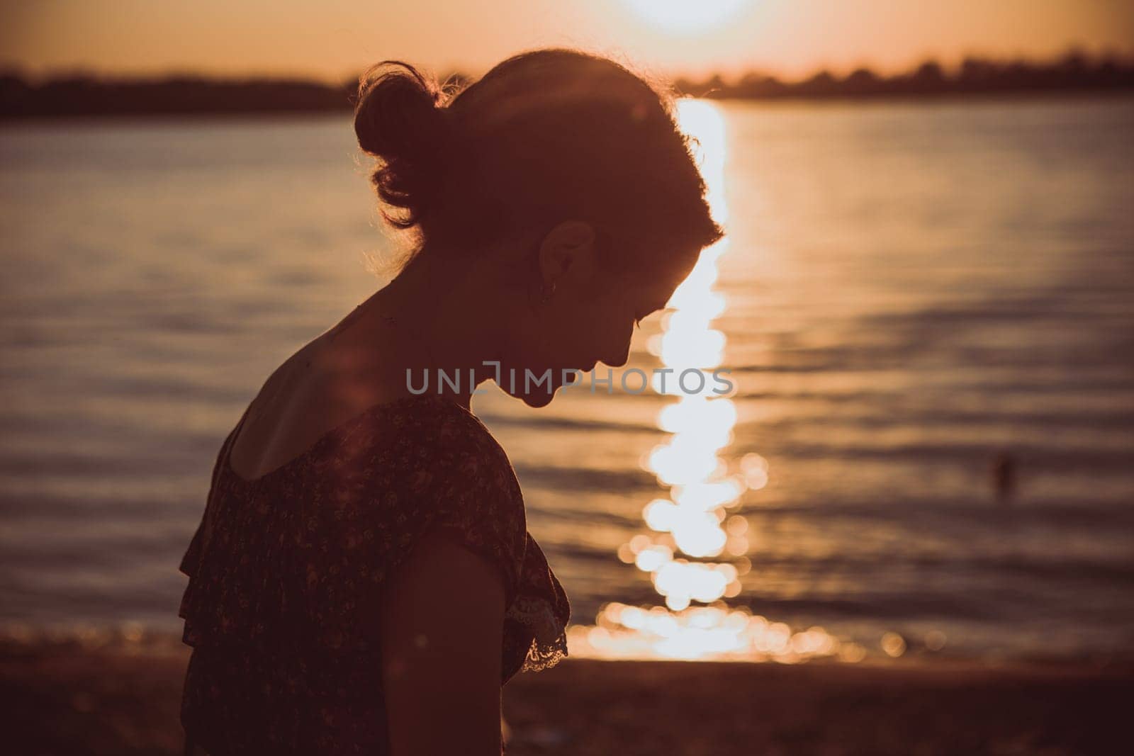 Beautiful young brunette girl sitting outdoors near the river