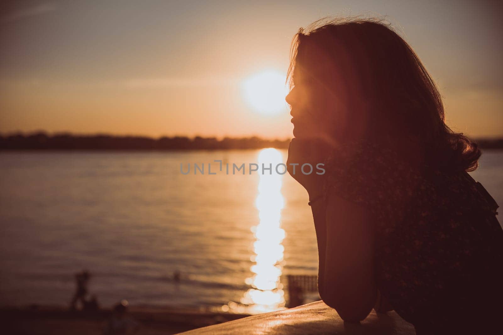 Beautiful young brunette girl sitting outdoors near the river