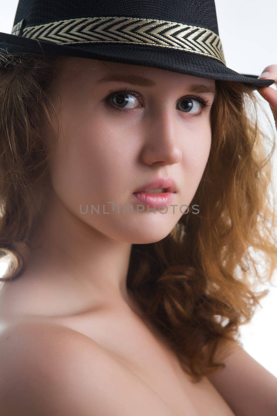 Sensual girl in a hat with a beautiful naked body.