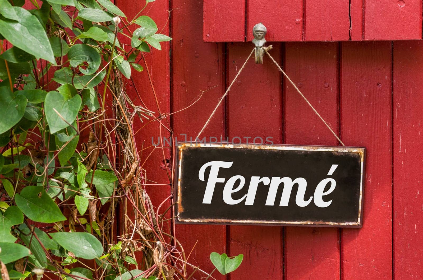 Old metal sign with the inscription Closed in french - Fermé