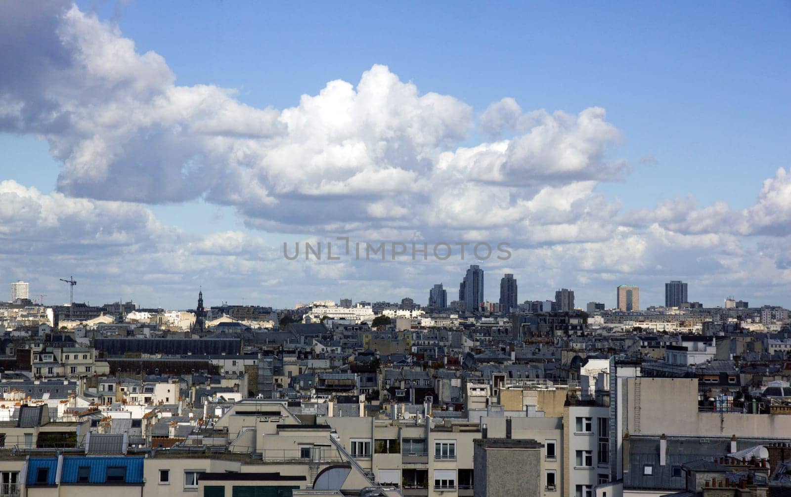 The rooftops of Paris under a threatening sky. Haussmannian architecture and modernity. (Paris, France)