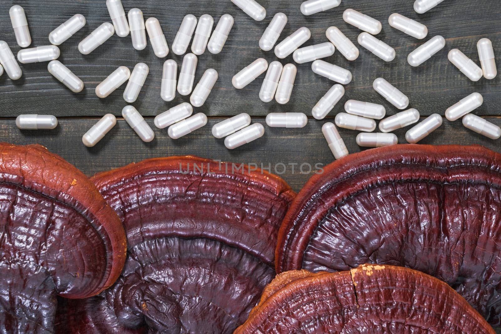 Close up of Ling zhi mushroom, Ganoderma lucidum mushroom and capsule on wood table