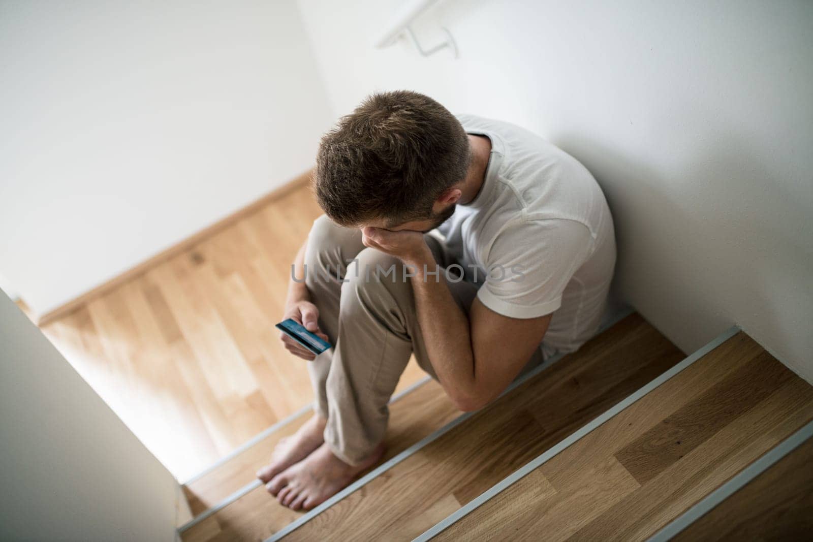 Depressed young man at home worried about finances