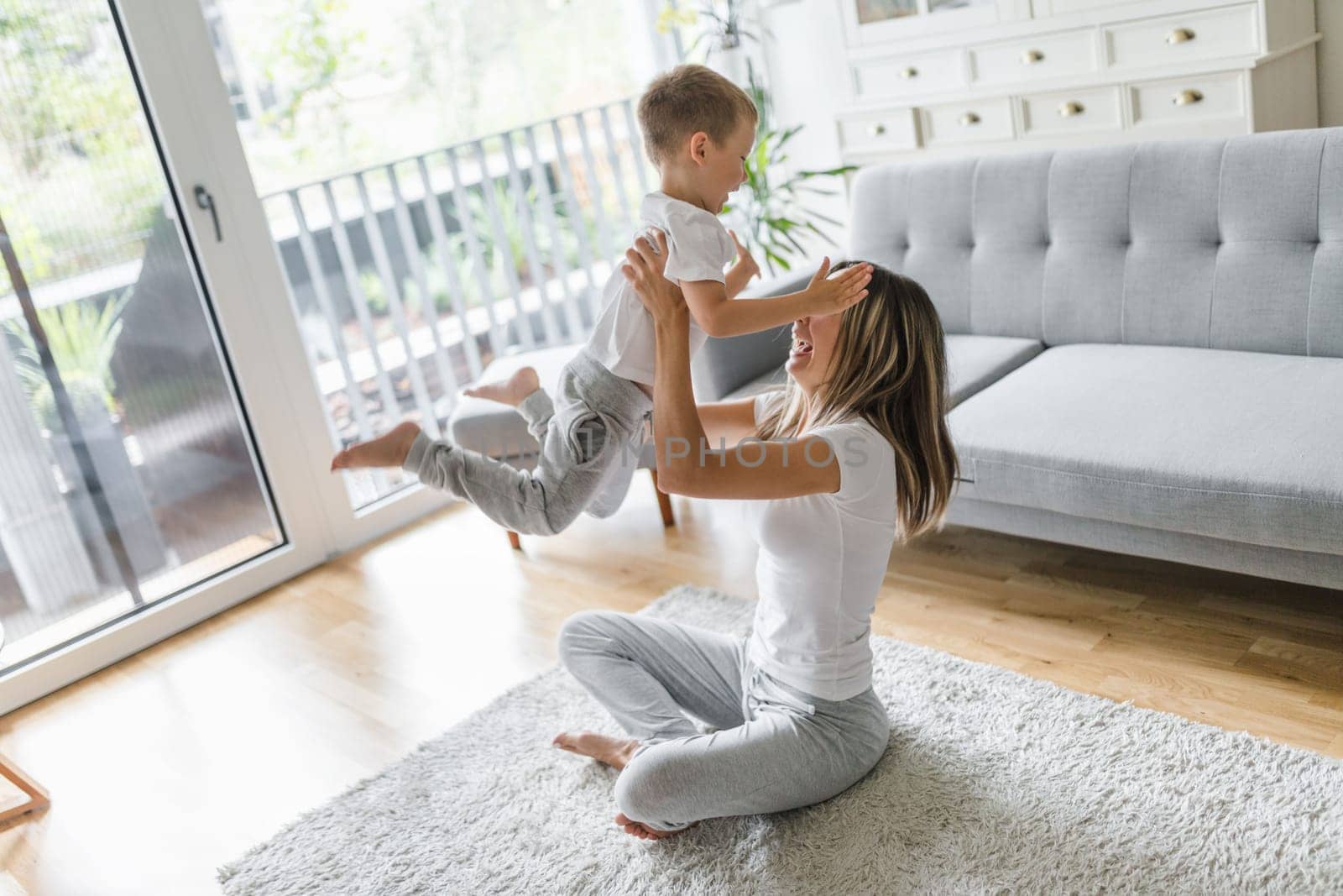 Mother with her son playing in their living room