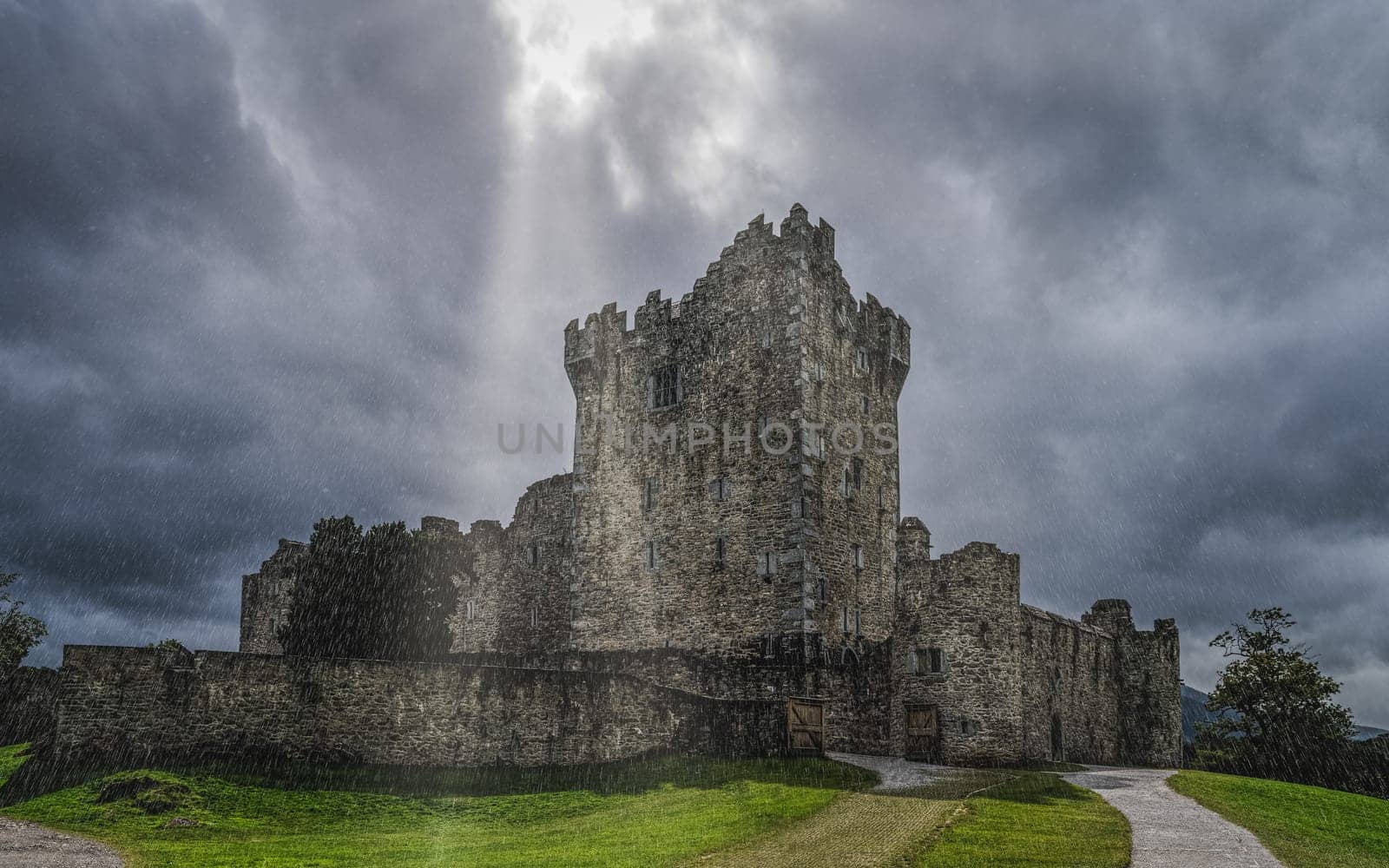 Ross Castle under very heavy lashing rain and thunderstorm with dramatic clouds, located on the bank of Lough Leane, Ring of Kerry, Killarney, Ireland