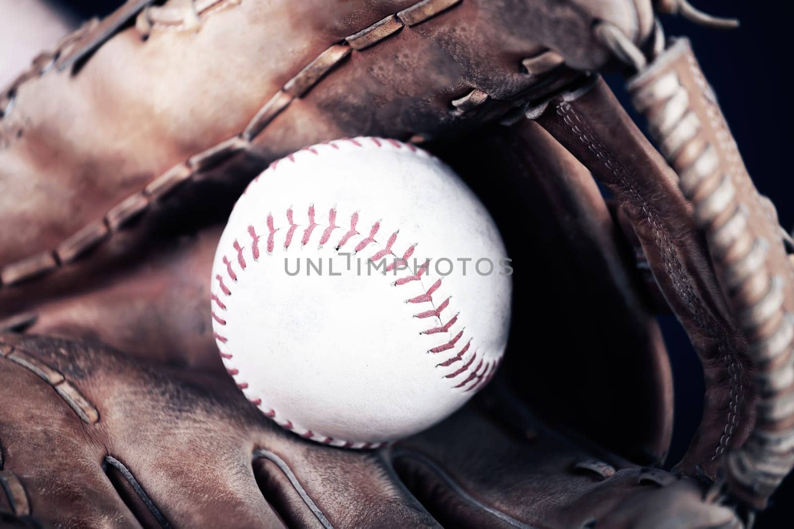 Close up image of an old used baseball and baseball glove.