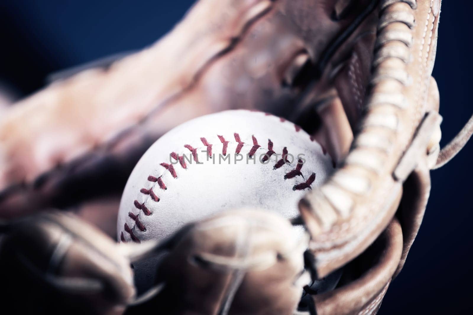 Close up image of an old used baseball and baseball glove.
