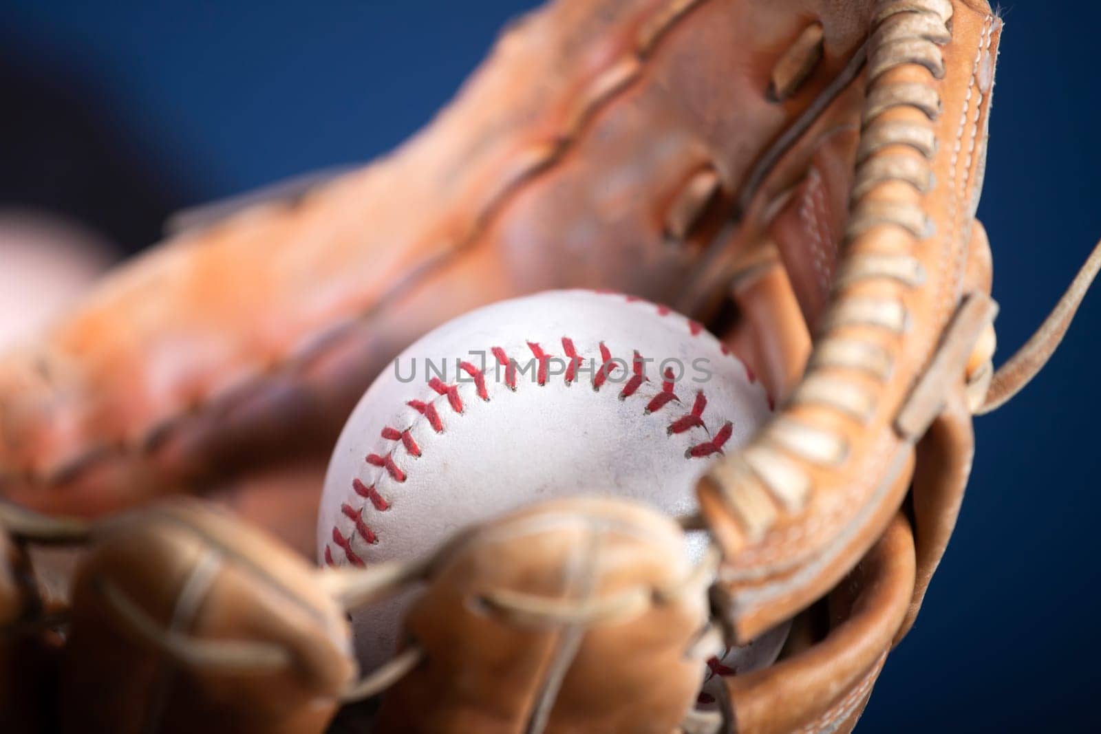 Close up image of an old used baseball and baseball glove.