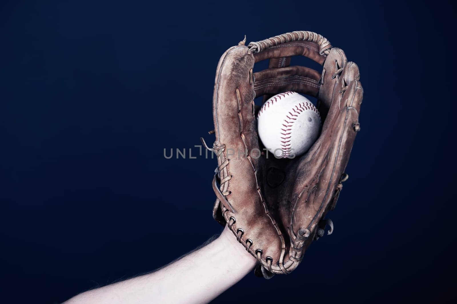 Close up image of an old used baseball and baseball glove.