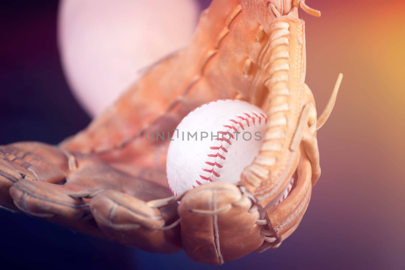 Close up image of an old used baseball and baseball glove.