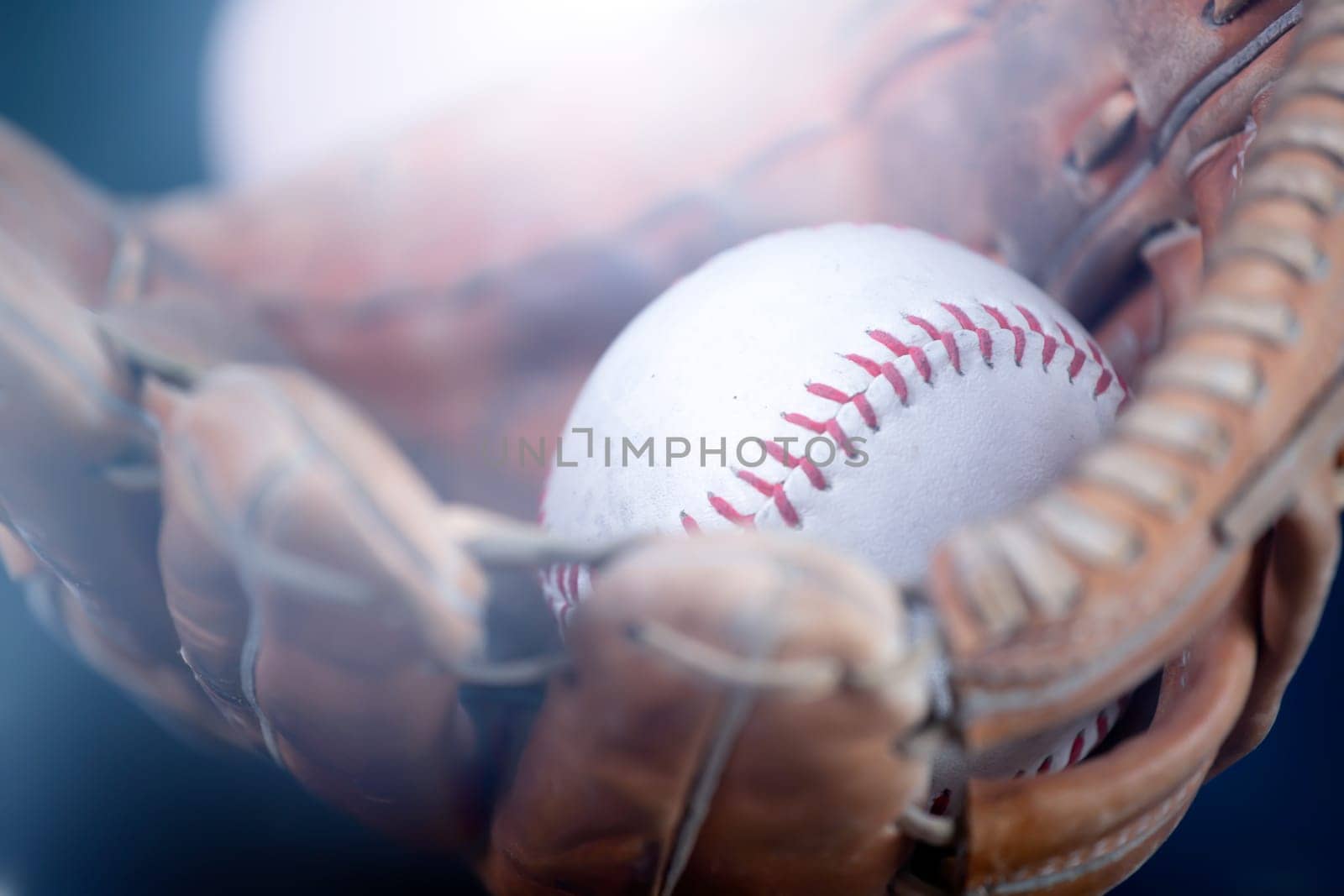 Close up image of an old used baseball and baseball glove.