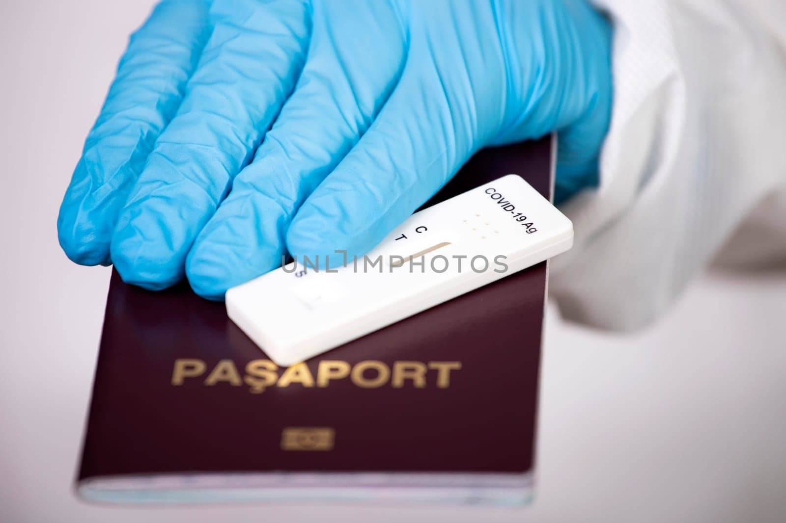 Doctor holding passport and negative covid-19 ( rapid antigen SARS-CoV-2 Ag ) test. Coronavirus and safety travel concept.