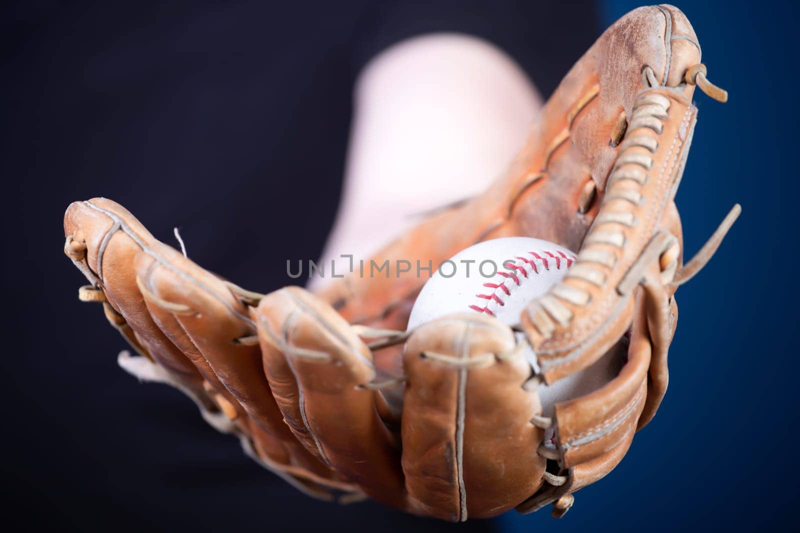 Close up image of an old used baseball and baseball glove.
