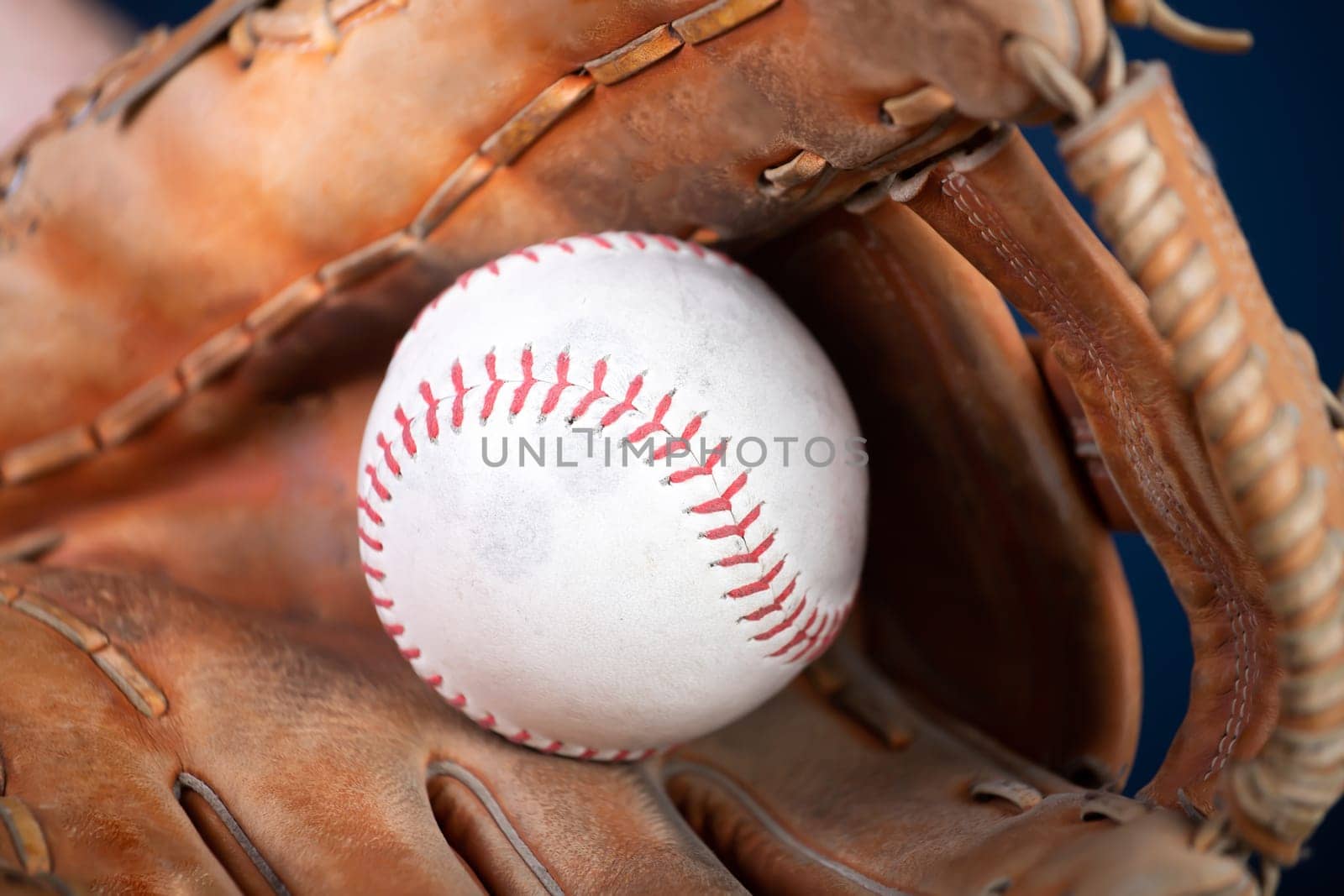 Close up image of an old used baseball and baseball glove.