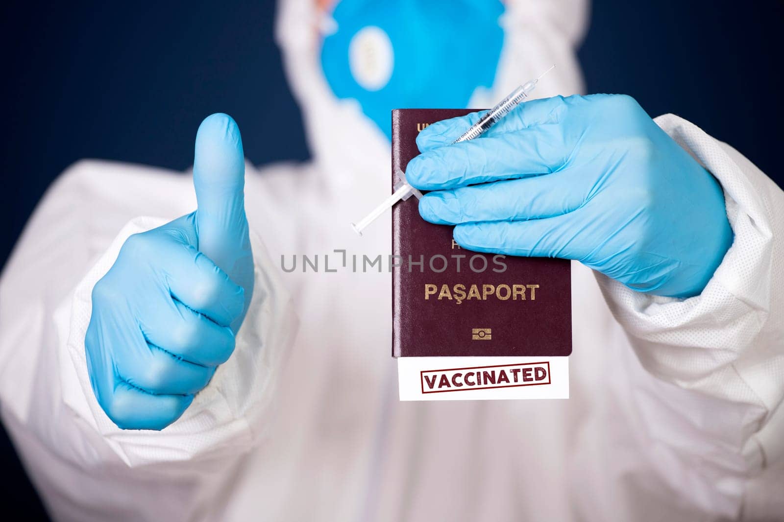 Doctor holding passport with VACCINATED sign and vaccine. Immunity passport, risk-free certificate concept.