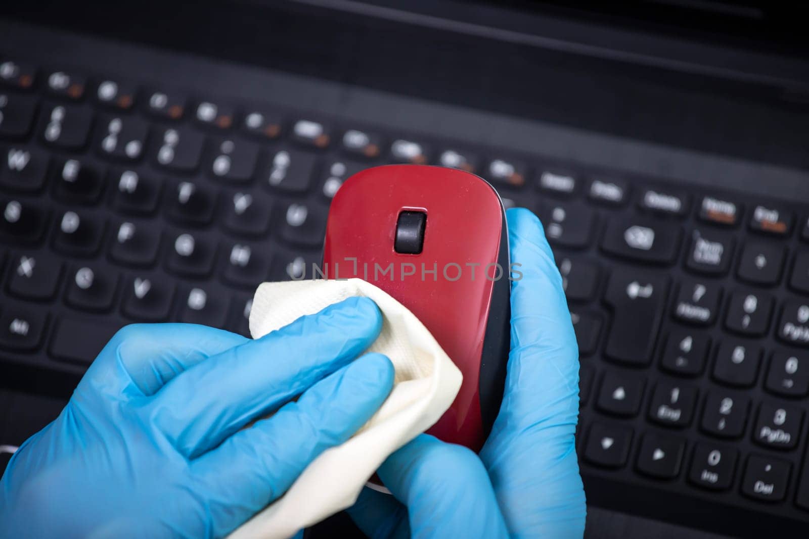 Office sanitizing wiping mouse with disinfectant. Coronavirus COVID-19 sanitize cleaning, disinfection of work desk.